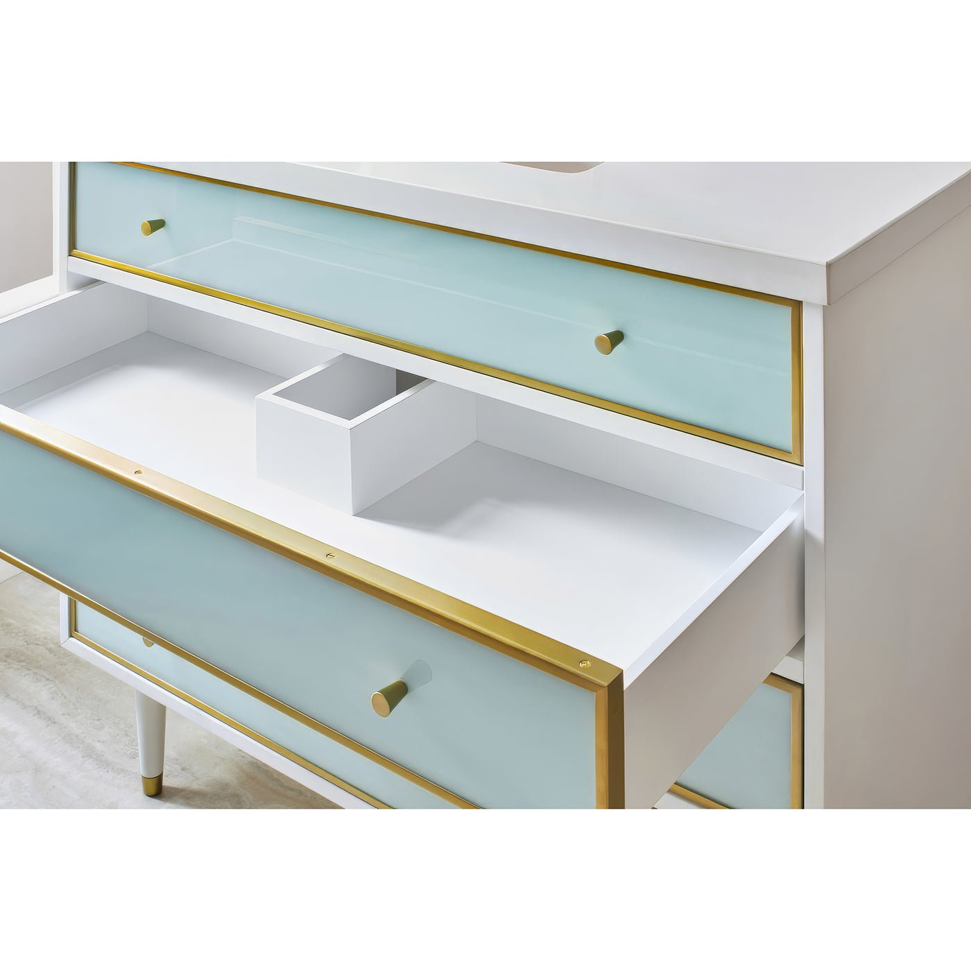 Open drawer of coastal vanity, storage detail, blue and gold.