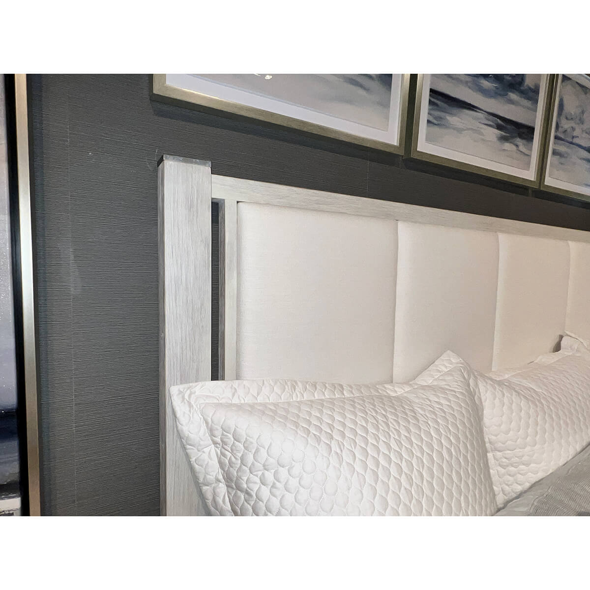 Headboard detail with white quilted pillows on bed.