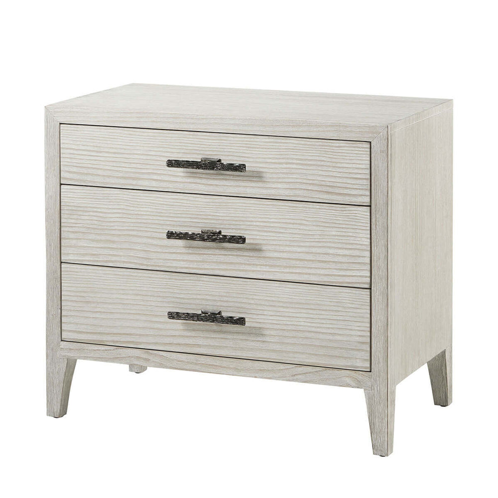 Three-drawer nightstand, light wood finish, angled front view.