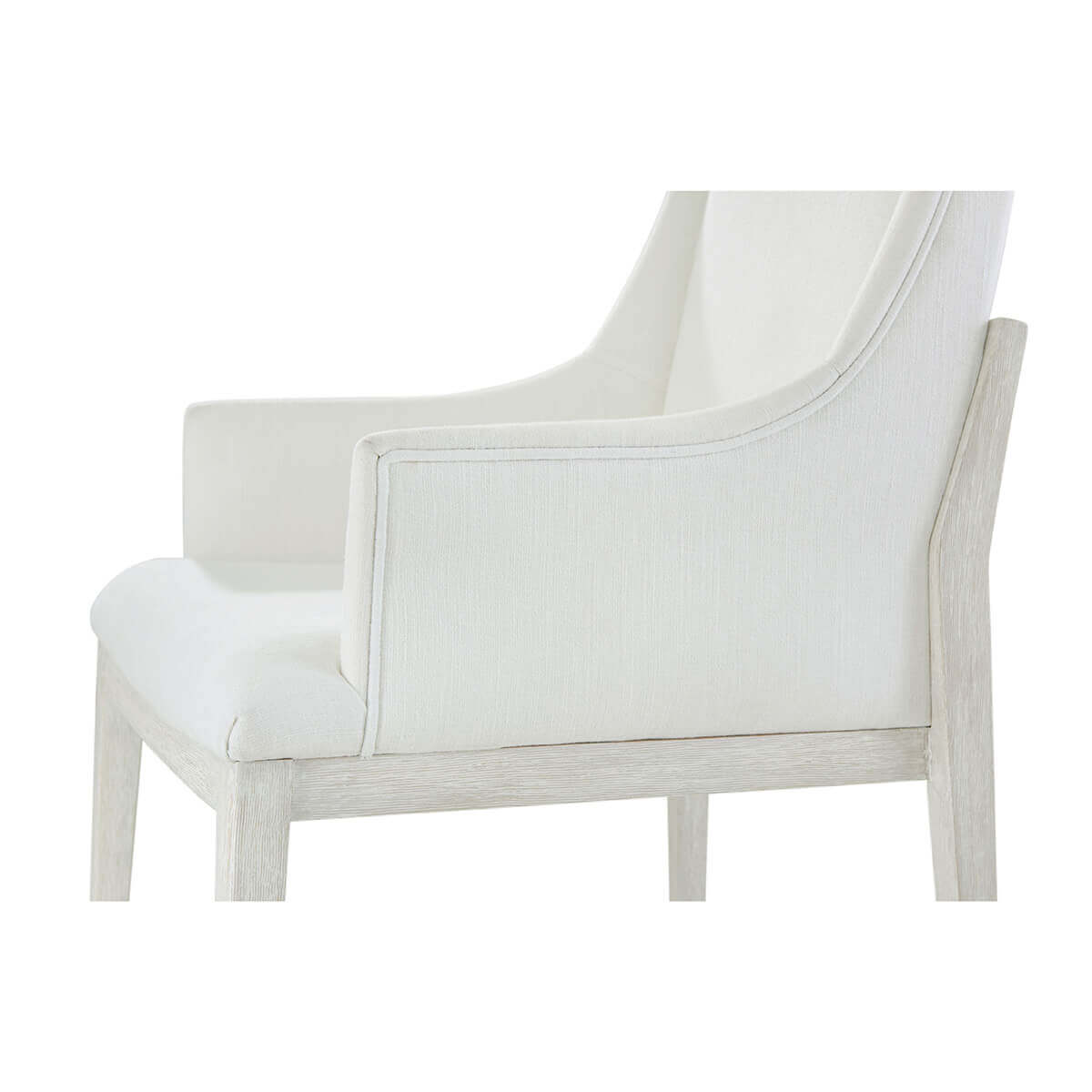 Side detail of white upholstered dining armchair.