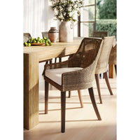 Coastal rattan dining chairs around wooden dining table setting.