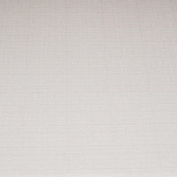 Close-up of white cushion on coastal rattan settee.