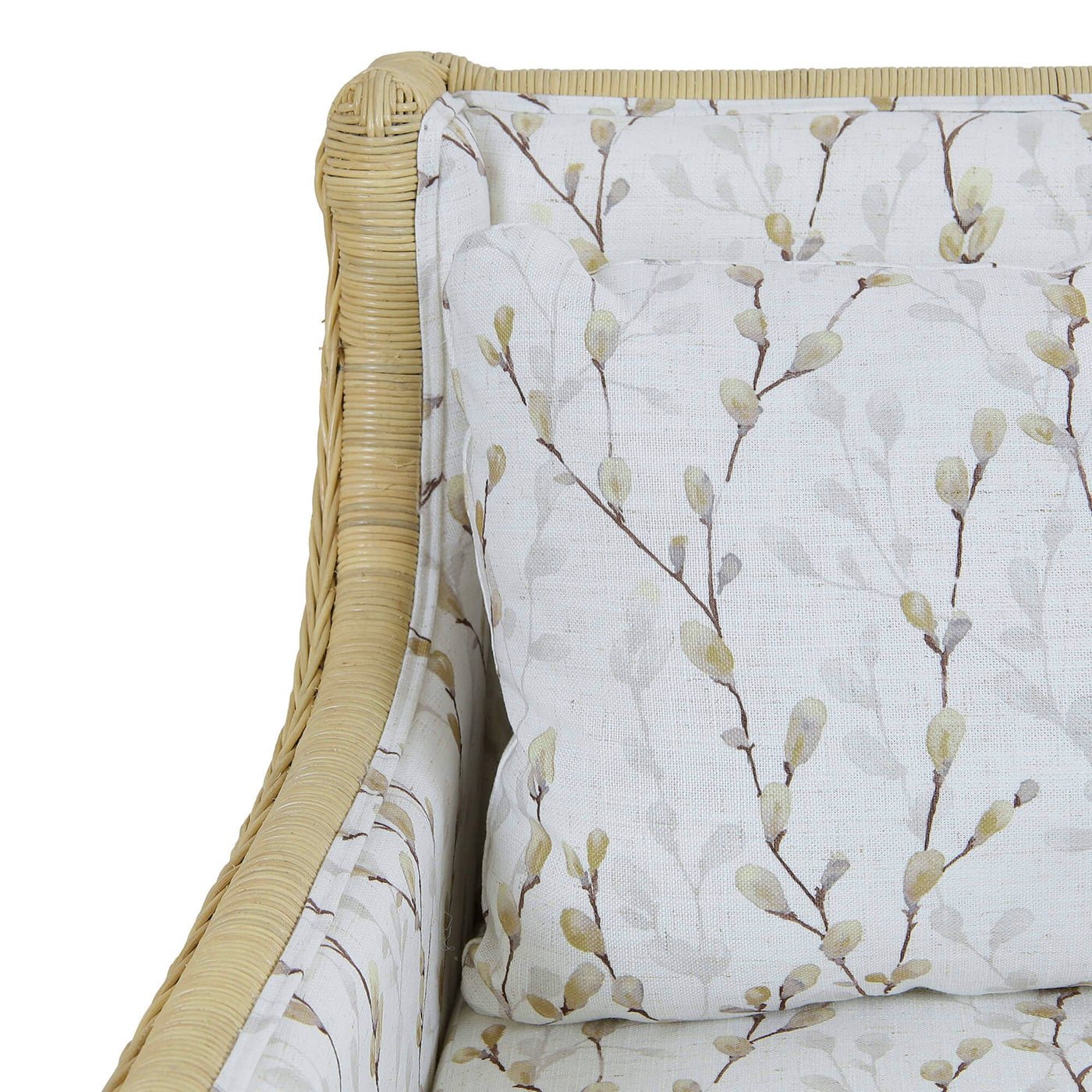 Close-up of armrest, floral cushion on rattan settee.