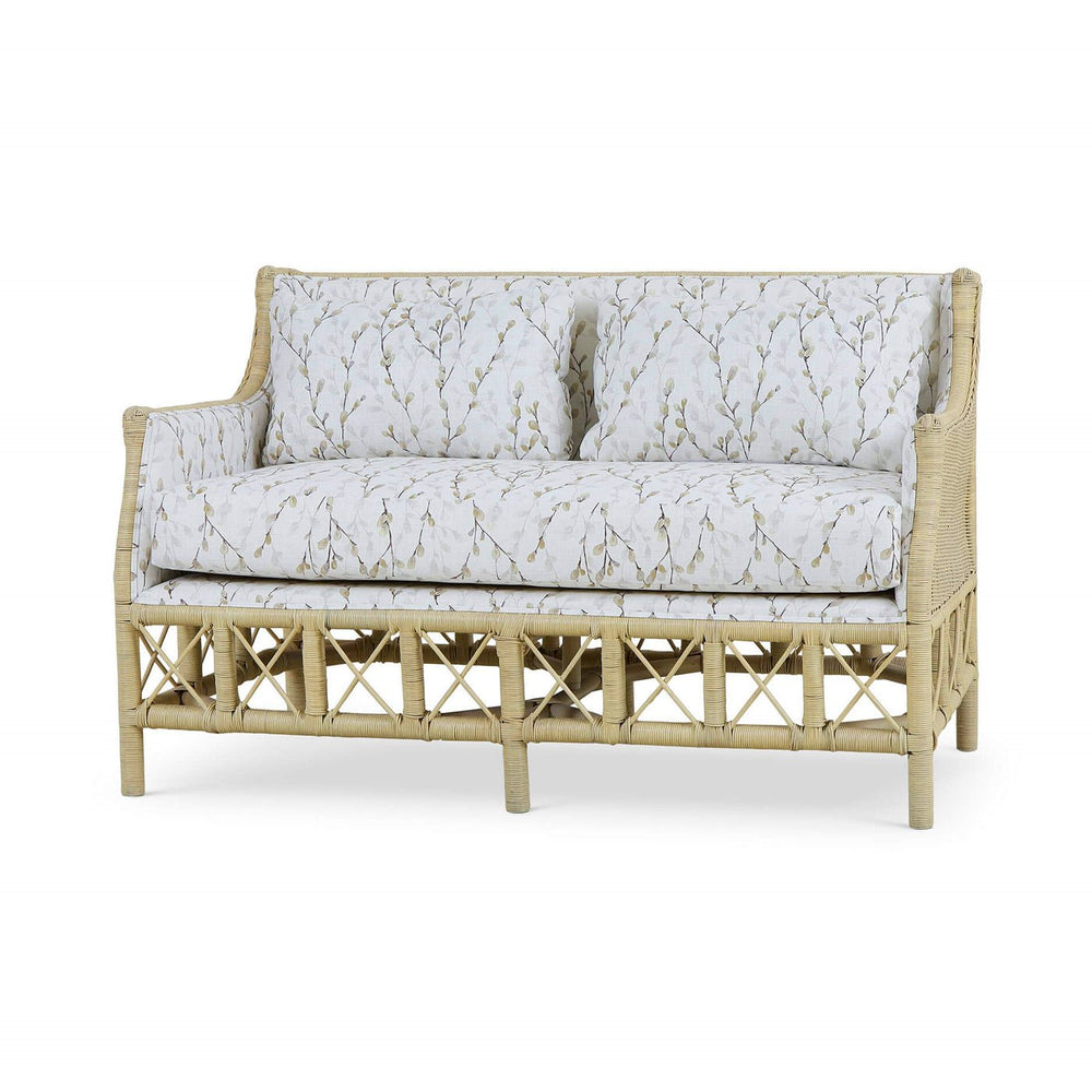 Wicker settee with botanical upholstery, three-quarter angle view.