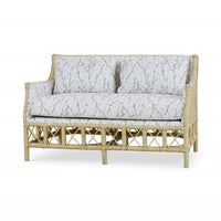 Wicker settee with botanical upholstery, three-quarter angle view.