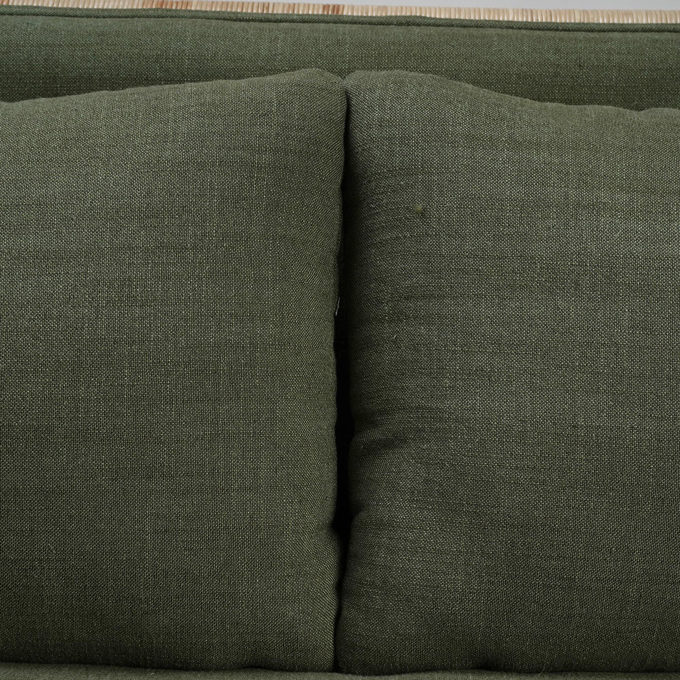 Close-up of green cushions on rattan settee.