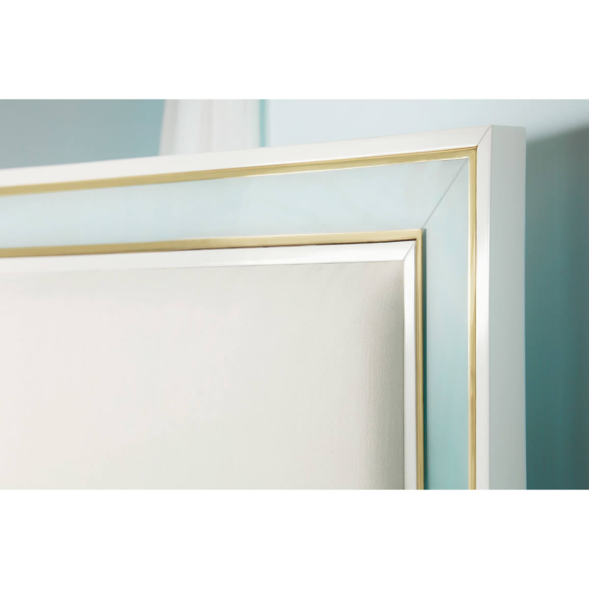 Close-up of bed frame with gold trim.