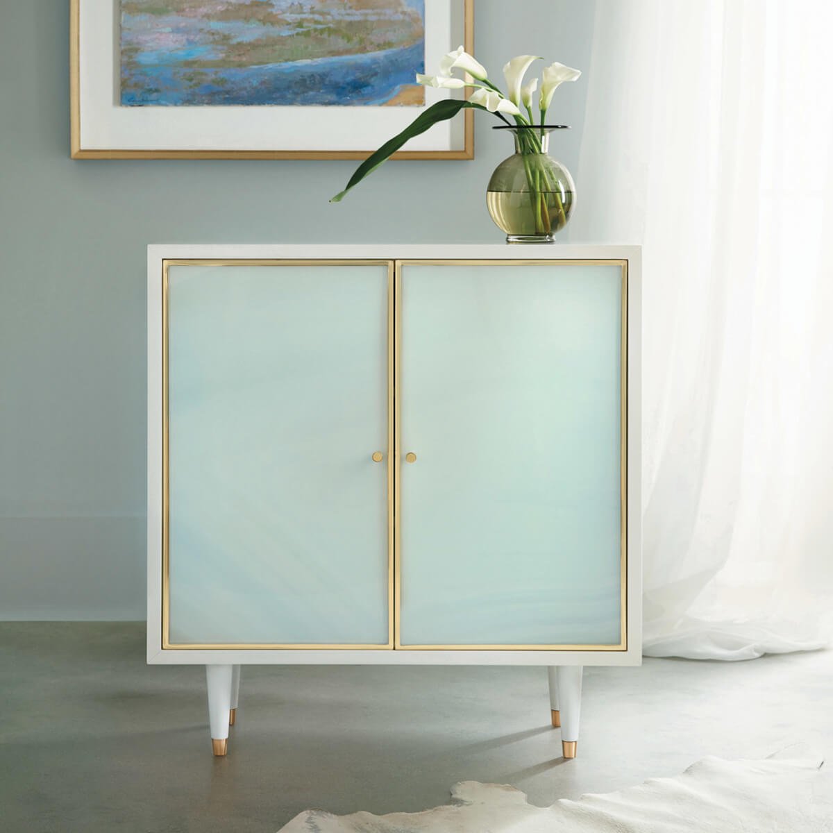 Sea glass cabinet styled in living room with flowers.