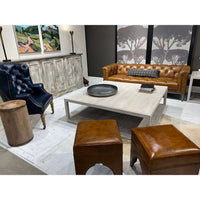 Coffee table in living room setup, leather sofa background.