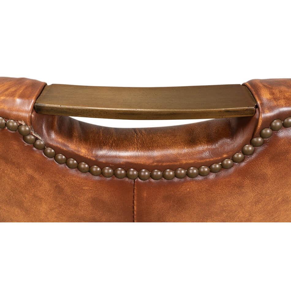 Cognac leather dining chair handle and nailhead close-up.