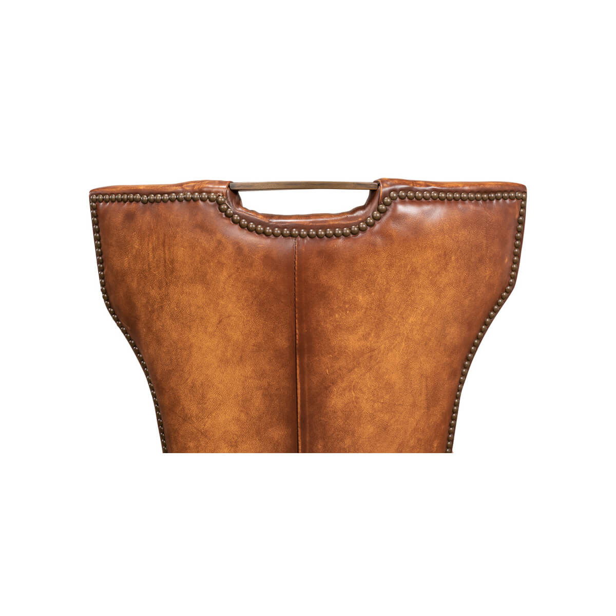 Cognac leather dining chair backrest upper part, nailhead detail.