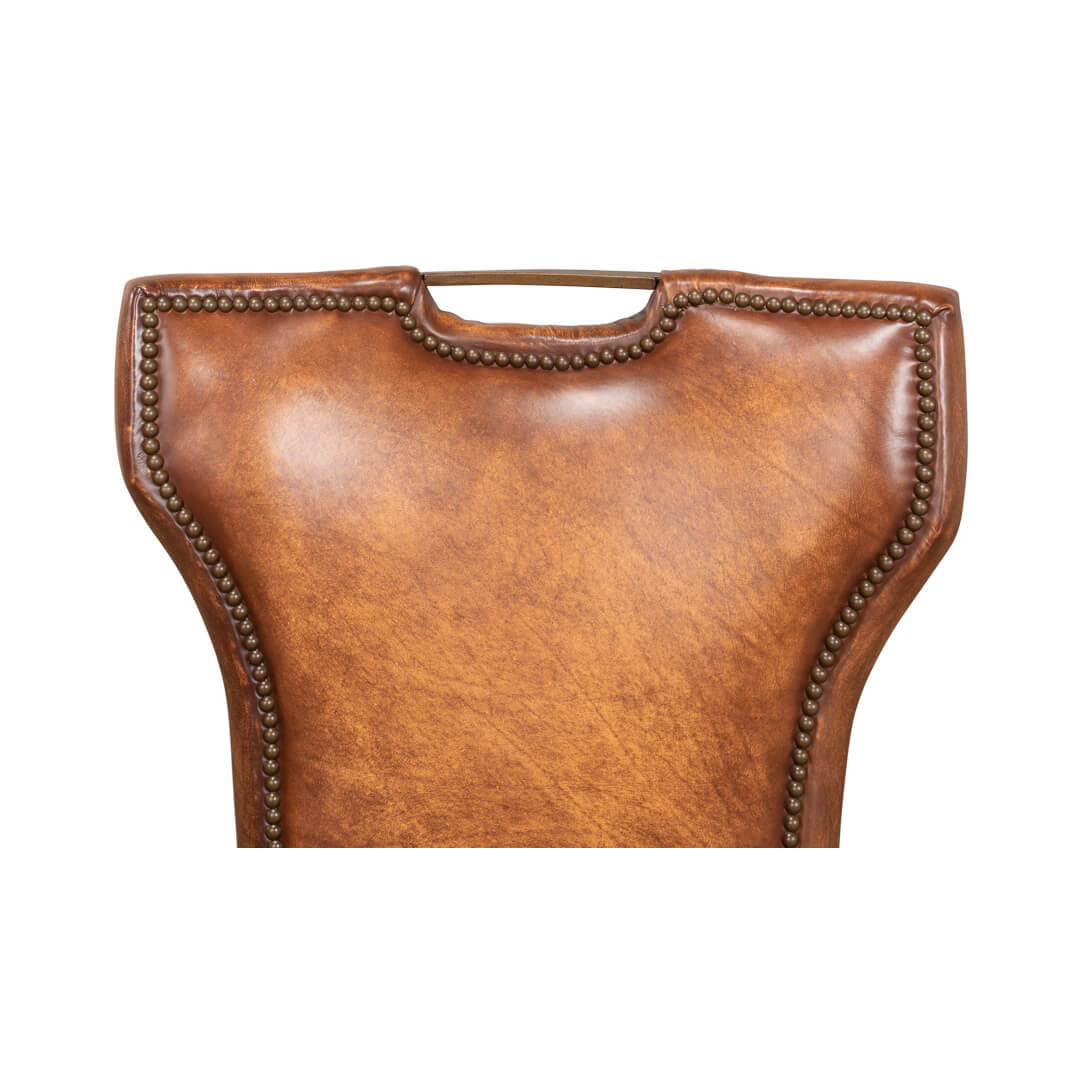 Cognac leather dining chair backrest close-up, nailhead trim.