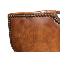 Cognac leather dining chair side nailhead trim close-up.