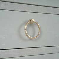 Close-up ring handle on blue linen sideboard drawer.