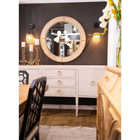 Cream linen sideboard with mirror, decorative accents and lights.