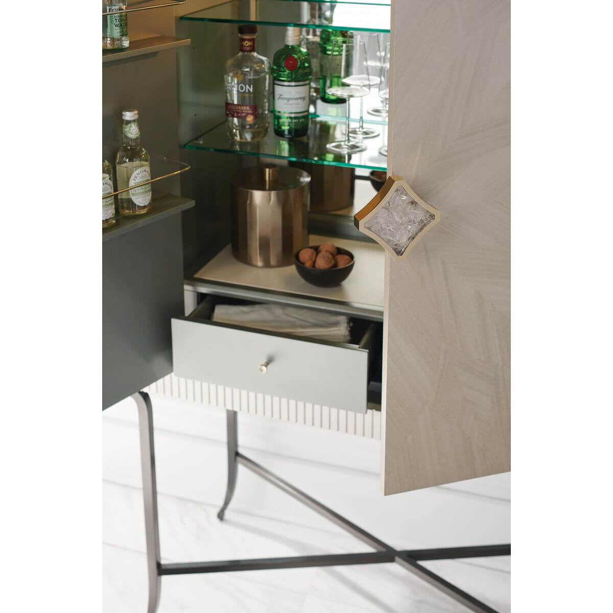 Close-up of open bar cabinet drawer with items inside.