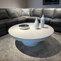 Contemporary round coffee table in living room, decorative vases.