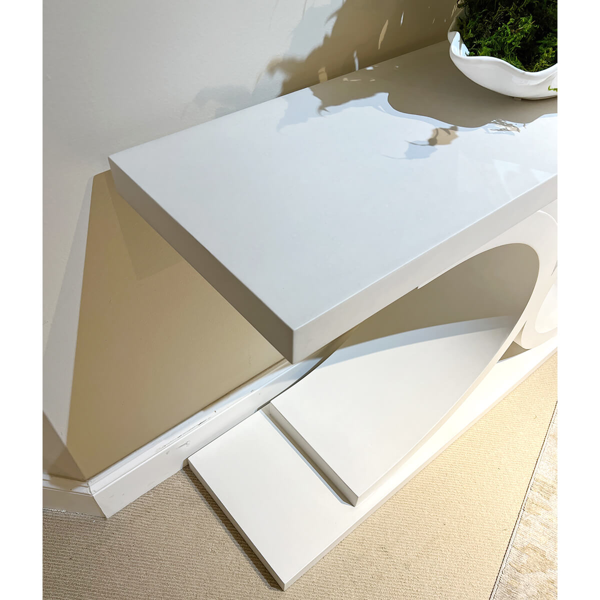 Close-up of white console table top and curved details.