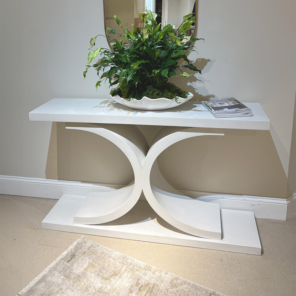 Console table styled with plant and magazine in hallway.