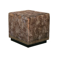 Copper velvet cube ottoman against a white wall.