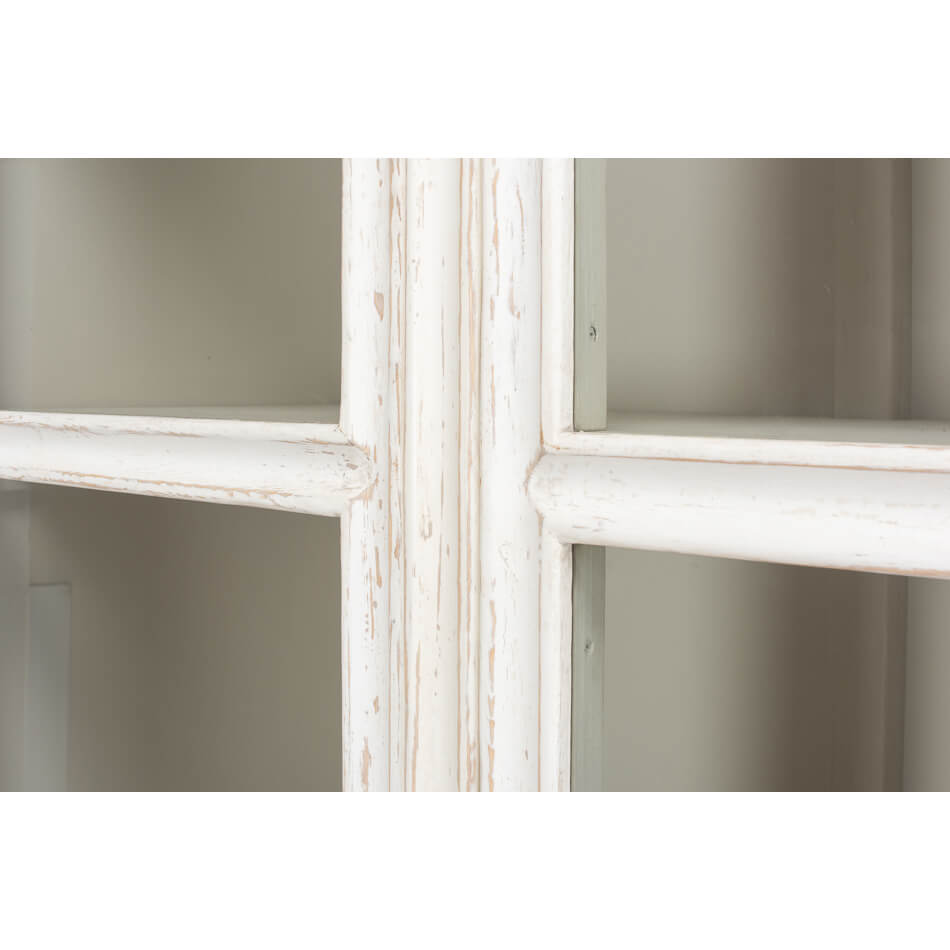 Glass panel detail on distressed white display cabinet.