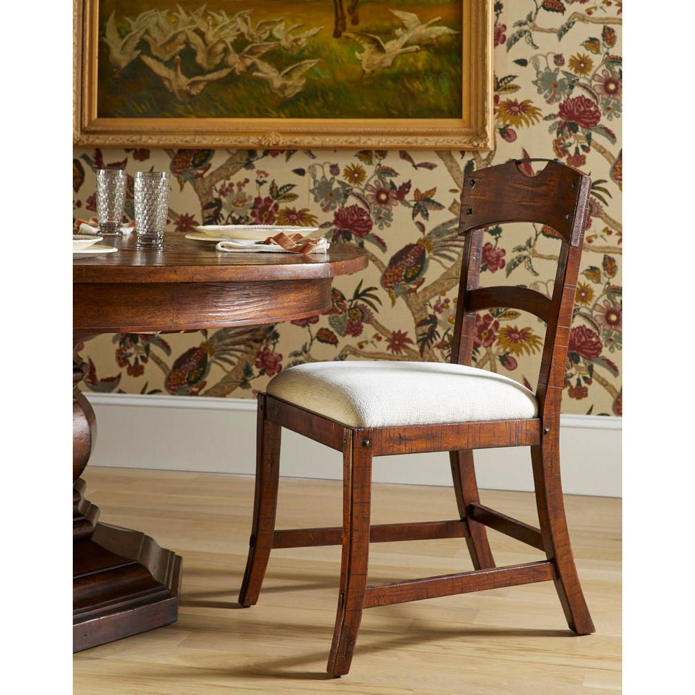 Country rustic dining chair beside a round dining table.