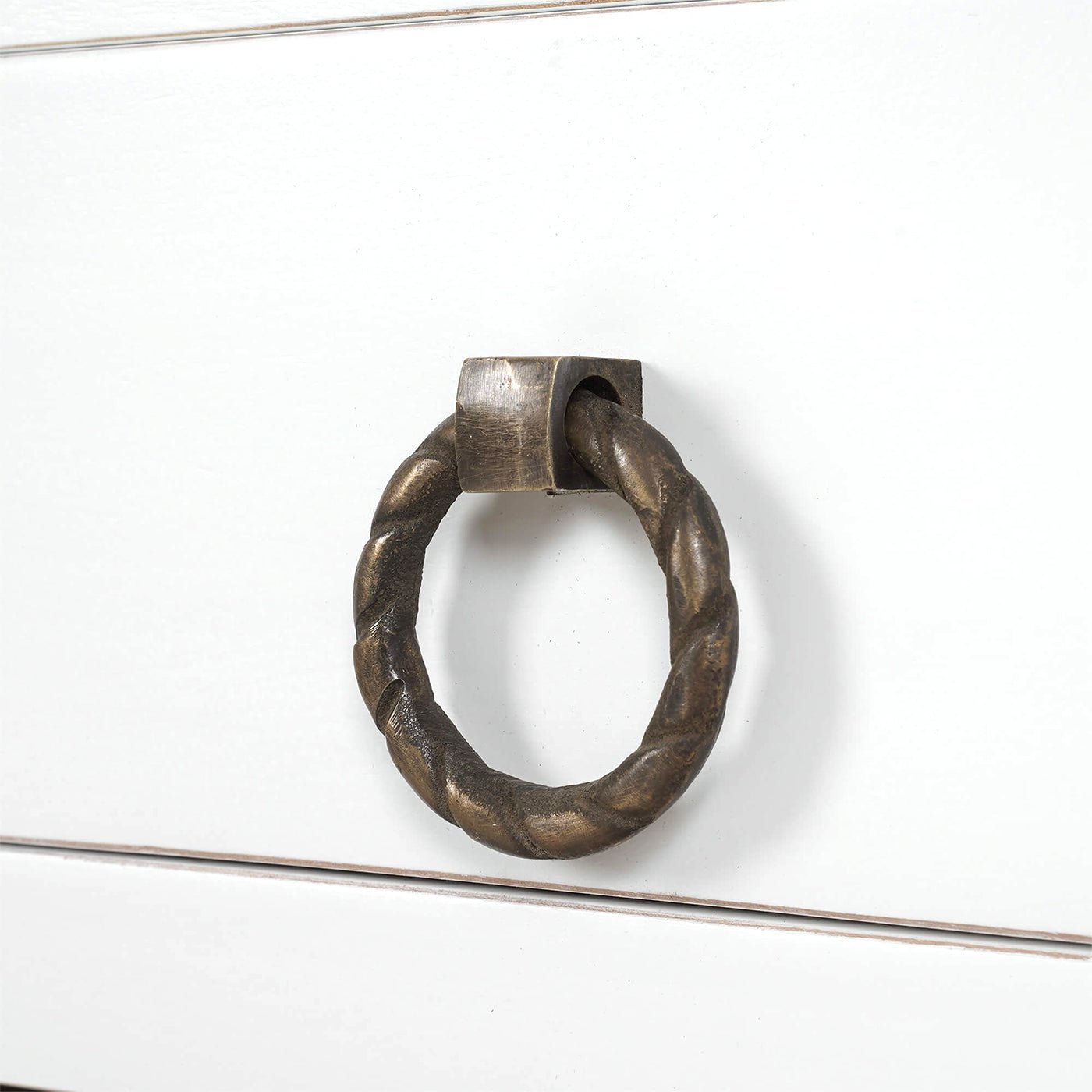 Close-up of kitchen island drawer handle, twisted metal design.
