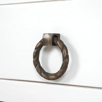 Close-up of kitchen island drawer handle, twisted metal design.