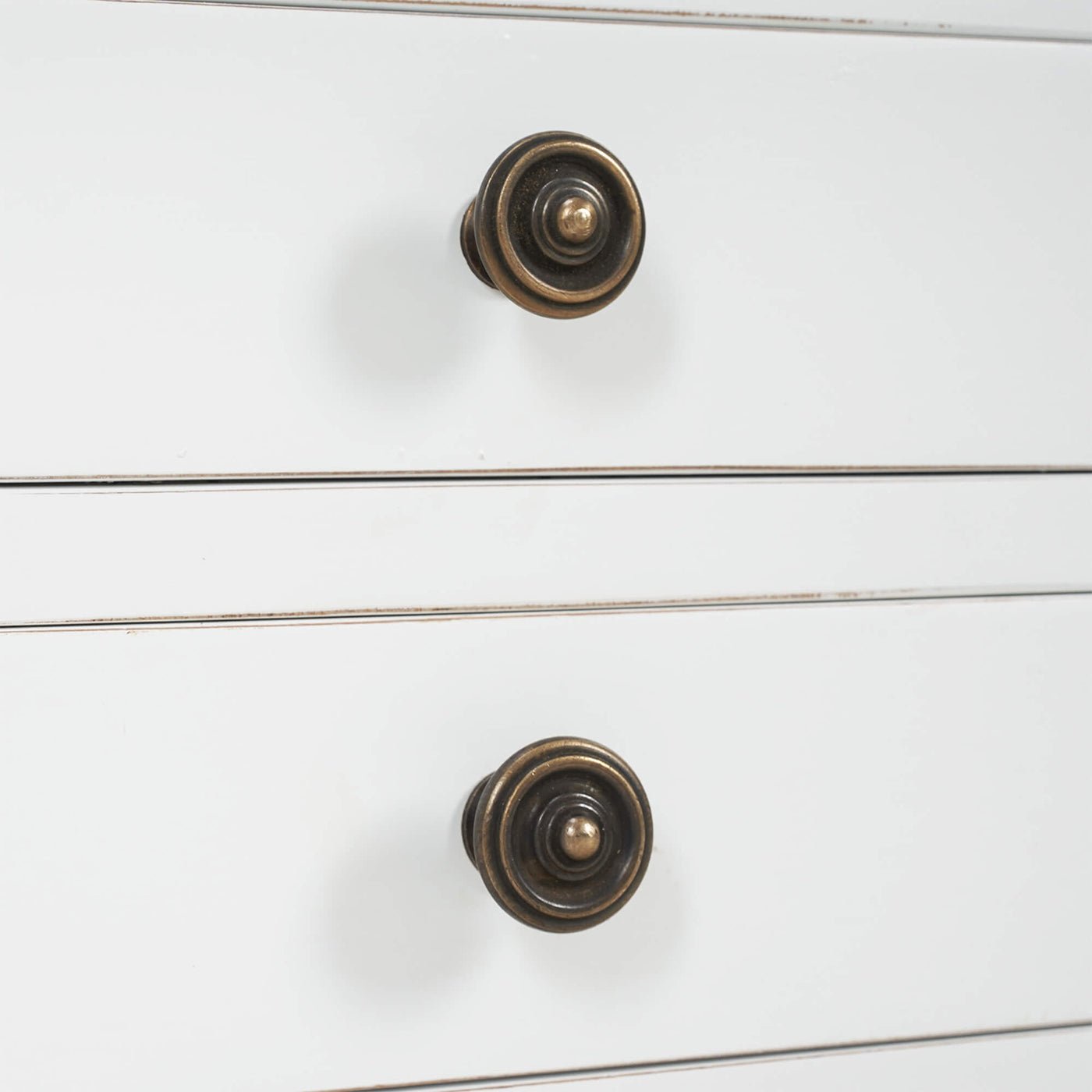 Close-up of white table, drawer knobs.