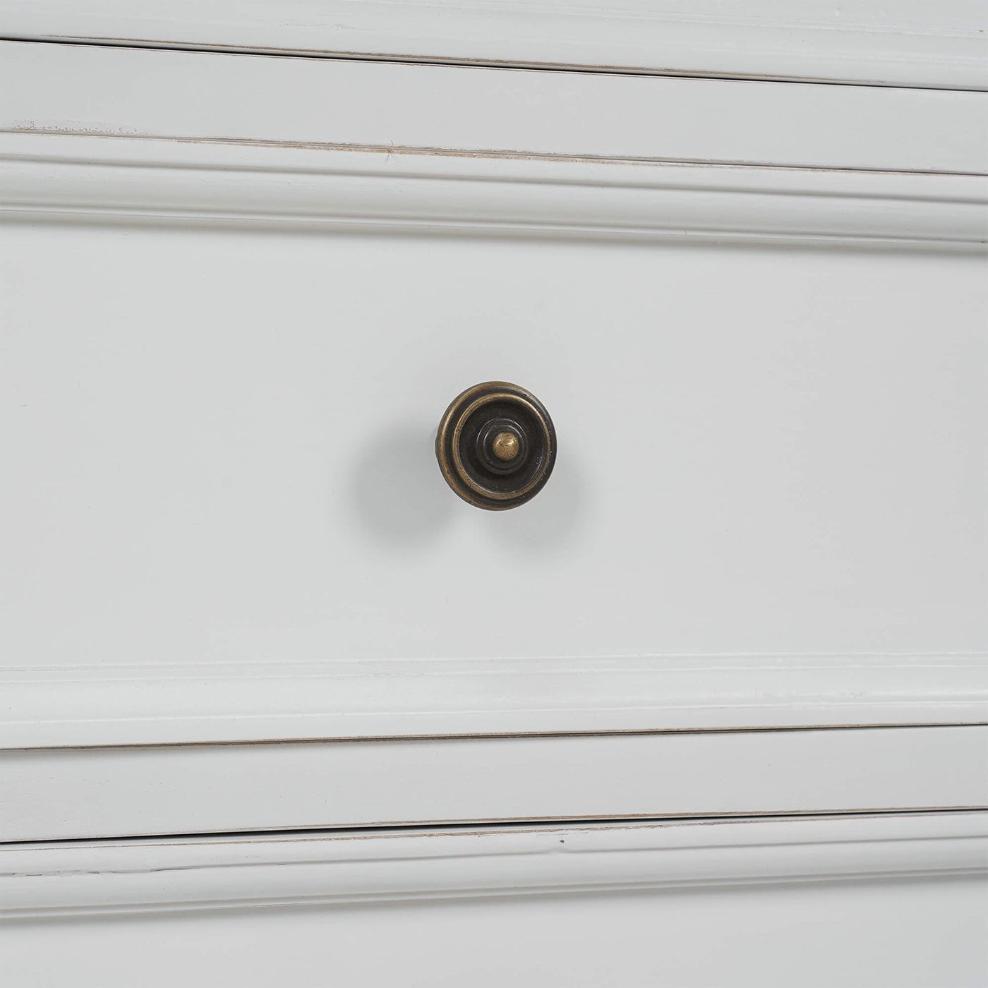 Close-up of drawer knob on white end table.