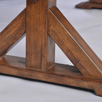 Base detail of dark wooden dining table leg.