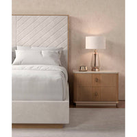 Nightstand beside cream upholstered king bed close-up