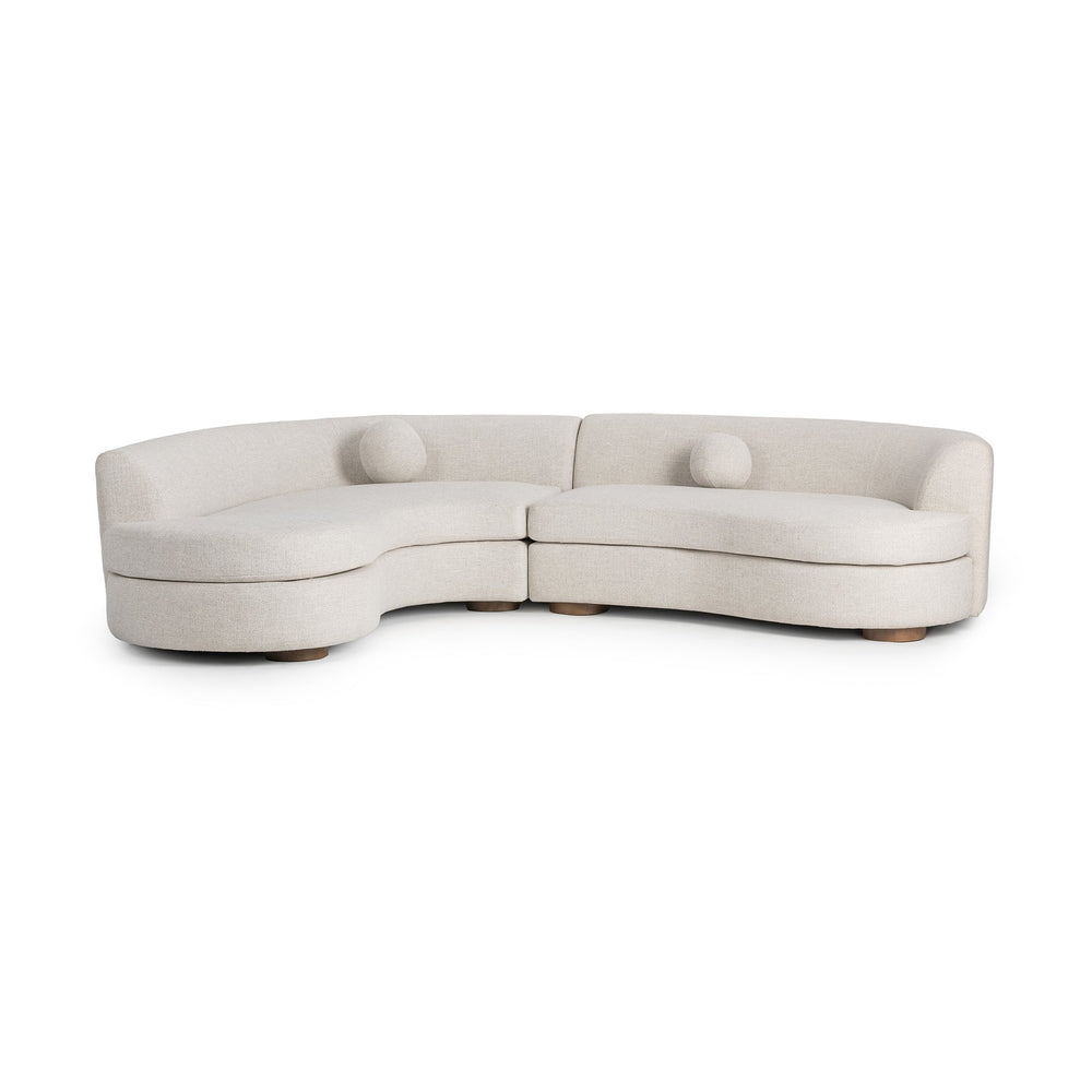 Angled front view of ivory two-piece bouclé sectional with curved seating and round accent pillows