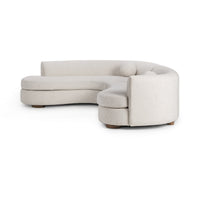 Side-angle view of ivory bouclé sectional showing its rounded end, curved back and low wood feet