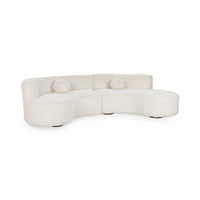 Front view of cream two-piece curved sectional with plush upholstery and two round accent pillows