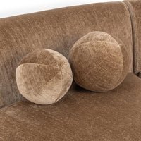 Close-up of two round brown accent pillows against the sectional back