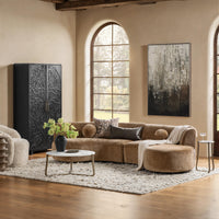 Brown curved sectional styled with a coffee table and rug beside an arched window