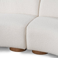Close-up of the ivory sectional center join, textured upholstery and two round wood feet