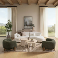 Ivory curved sectional styled in a living room with green accent chairs and round coffee tables