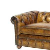 Detailed view Chesterfield sofa arm, intricate tufted craftsmanship.