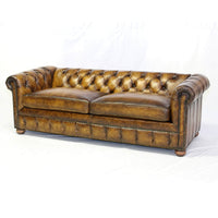 Antiqued leather Chesterfield, angled view, rich brown color.
