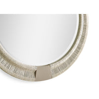 Bottom detail of round mirror showing metal accent.