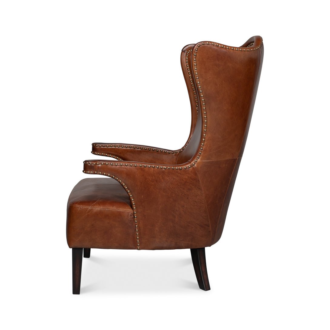 Side profile of dark brown high back leather wing chair.