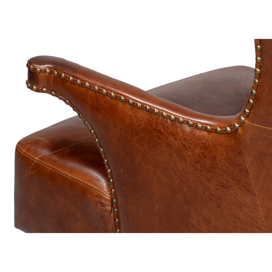Close-up, arm detail of dark brown leather wing chair.