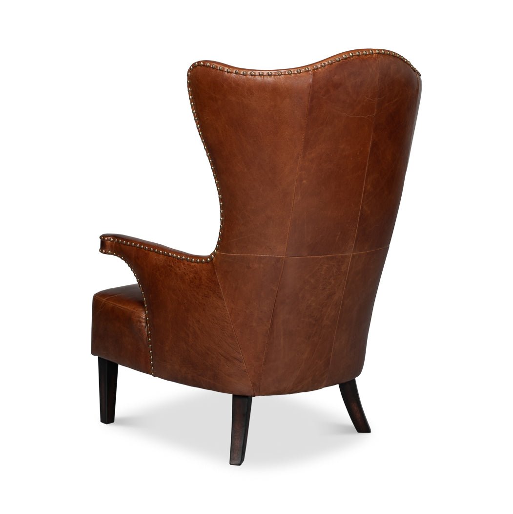 Back angle view of dark brown leather wing chair.