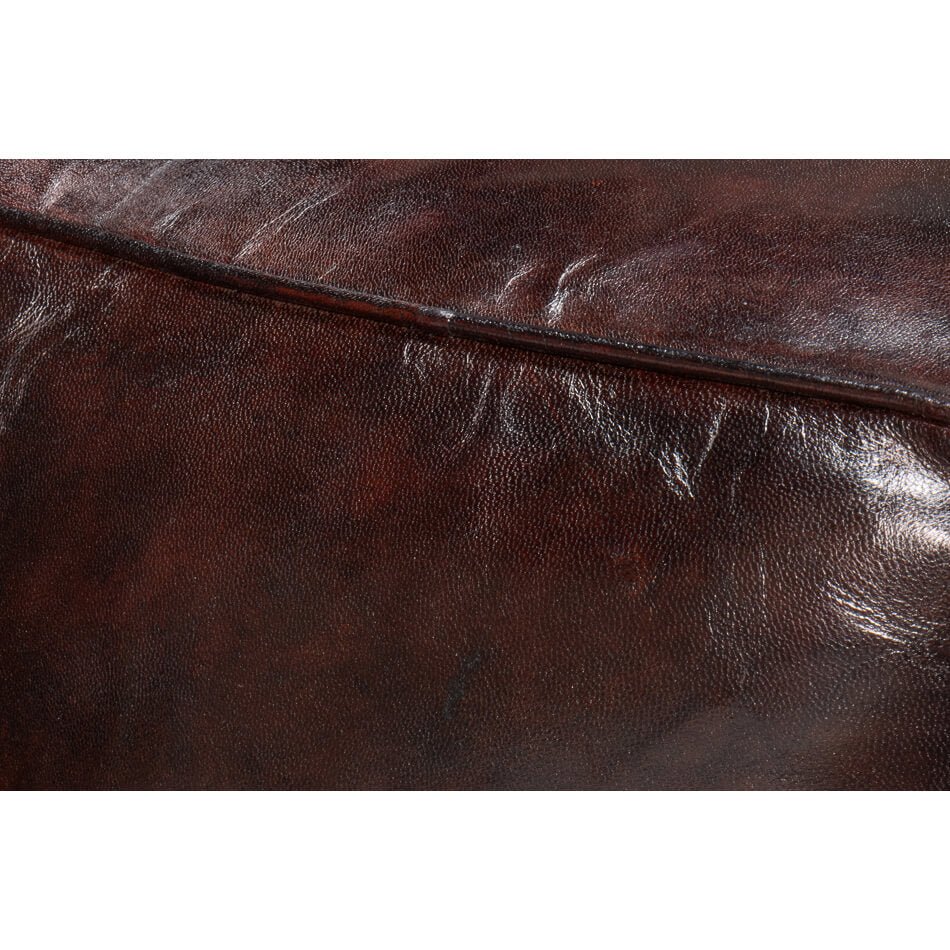 Close-up texture of dark brown leather cube stool.