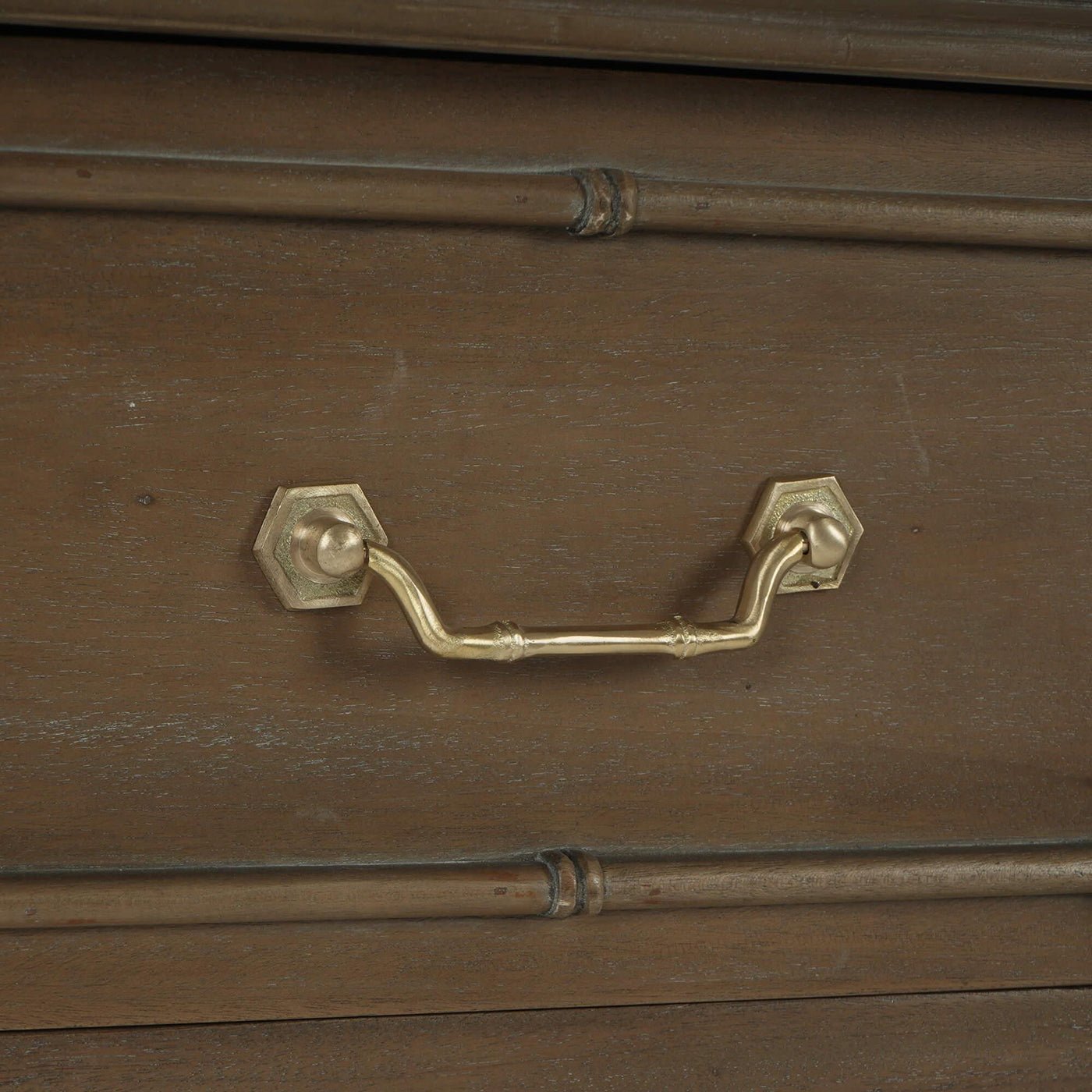 Handle detail of faux bamboo end table drawer.