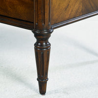 Dark French Louis XVI commode, leg detail showcasing design.