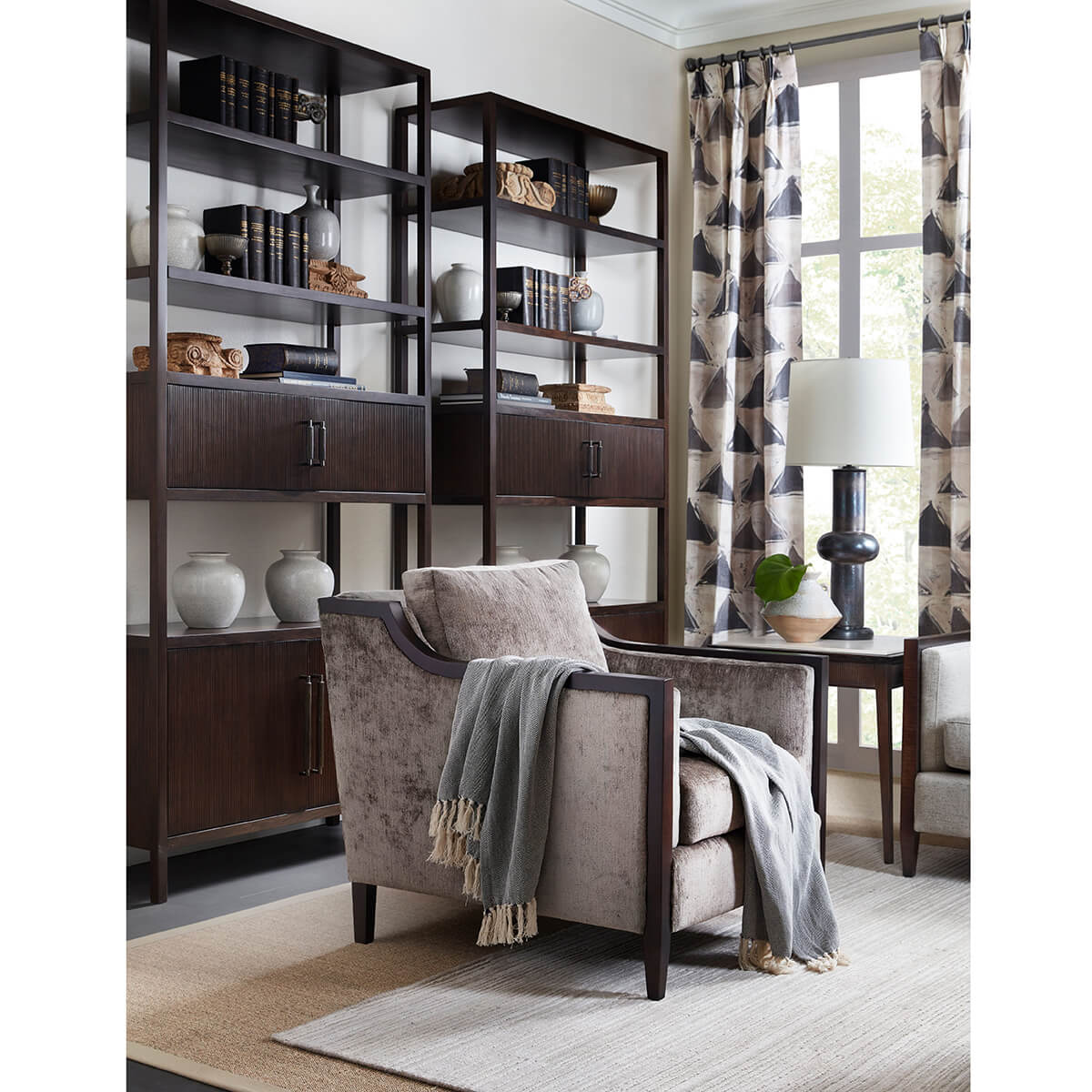 Dark open bookcase in stylish living room setup.