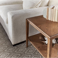 Dark oak side table, close-up with decor, next to sofa.